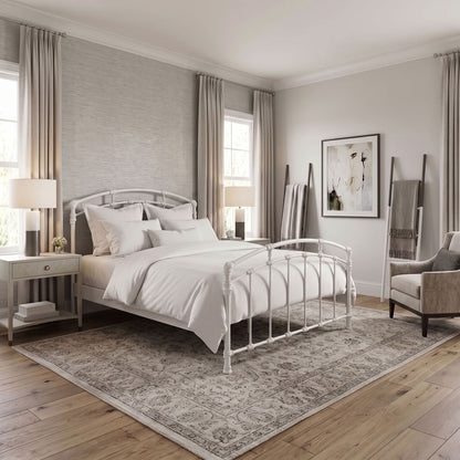 Test Iron Bed by Wesley Allen in Matte White finish in Queen size platform frame with wood slats. A white metal bed frame with a classic turned-post design, styled in a bright, modern bedroom with white bedding, a large patterned area rug, and light gray walls.